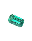 Faceted natural colombian loose emerald on a white background