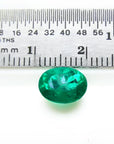 2.11 ct oval cut deep bluish-green Colombian emerald next to a ruler for scale.