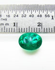 2.11 ct oval cut deep bluish-green Colombian emerald next to a ruler for scale.