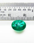 2.11 ct oval cut deep bluish-green Colombian emerald next to a ruler for scale.