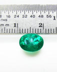 2.11 ct oval cut deep bluish-green Colombian emerald next to a ruler for scale.