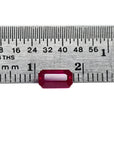 0.94 carat natural Burma ruby, emerald cut, vibrant red, displayed on a ruler.
