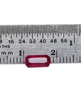 Sparkling 0.97 carat medium deep rich red emerald cut natural Burma loose ruby next to a ruler.