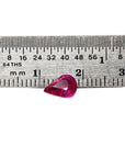 1.09 carat loose natural Burmese ruby, pear shape, sparkling medium red, shown with ruler for scale.