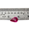 1.09 carat loose natural Burmese ruby, pear shape, sparkling medium red, shown with ruler for scale.