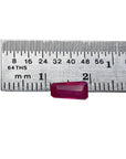 Deep red 1.07 ct. natural loose Burma ruby, tapered baguette cut, next to a ruler.
