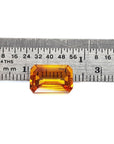 4.05 carats loose natural sapphire emerald-cut Intense yellow hue, on a ruler for scale