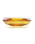 Vibrant 4.05 ct. natural yellow sapphire, emerald-cut, on a white background.