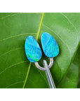 Blue opal earrings on a green leaf