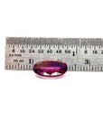 Loose natural pink sapphire oval cut from Sri Lanka, on a ruler for scale measurement