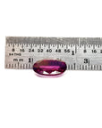 3.51 ct. natural medium pink oval sapphire with intense brilliance next to a ruler.