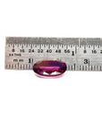 3.51 ct. natural medium pink oval sapphire with intense brilliance next to a ruler.