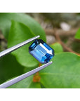 3.53 ct GIA certified natural greenish-blue sapphire, rectangular emerald cut, held by tweezers.