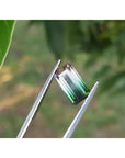 3.20 ct. loose Brazilian watermelon tourmaline gemstone with strong green and soft pink hues, held by tweezers.