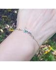 Emerald Love Bracelet: 14K white and yellow gold with a round cut Colombian emerald.