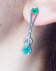 White gold with Love Knot Colombian emerald earring worn by a person