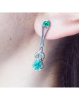 White gold with Love Knot Colombian emerald earring worn by a person