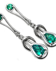 Pair of Love Knot emerald earrings pear cut in white gold on a white background