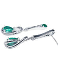 Pair of 14K white gold love knot earrings with pear-shaped Colombian emeralds.