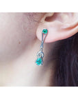 White gold Love Knot emerald earring worn by a person