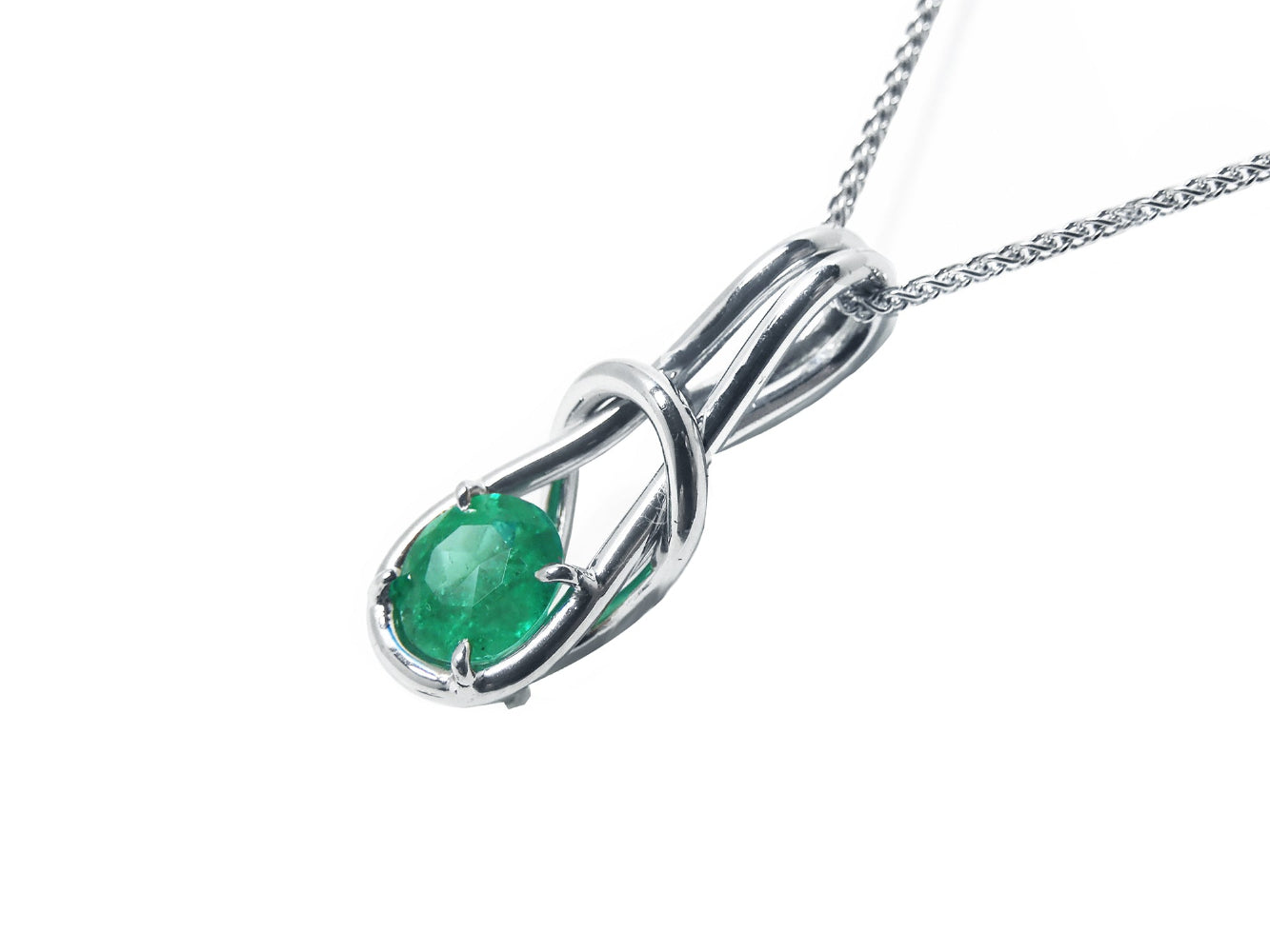 Right profile of this love knot emerald pendant, gallery underside view.