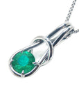 This love knot pendant necklace in white gold with a natural colombian emeralds displays its top and left- side profile.