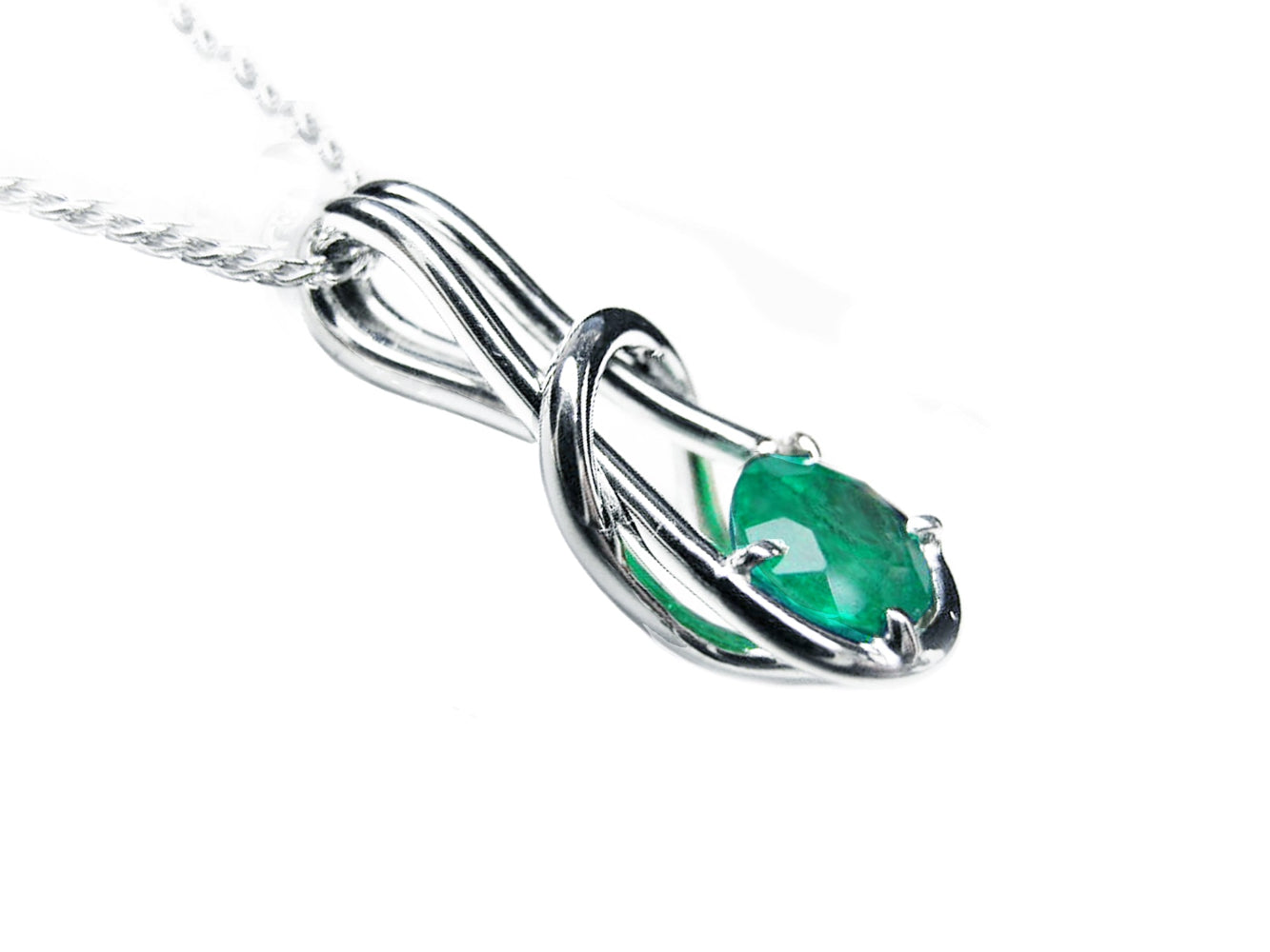 A white gold emerald love knot pendant necklace right side profile visible.