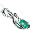 A white gold emerald love knot pendant necklace right side profile visible.