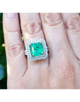 14k white gold ring with a certified natural colombian emerald on a finger.