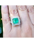 4.14 ct GIA-certified F1 Colombian emerald ring with diamonds in 14K white gold on a hand.