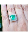 4.14 ct GIA-certified F1 Colombian emerald ring with diamonds in 14K white gold on a hand.