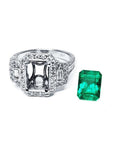 18K white gold engagement ring setting with diamond halo and baguette side diamonds, next to a vibrant emerald.