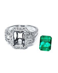 18K white gold engagement ring setting with diamond halo and baguette side diamonds, next to a vibrant emerald.