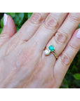Natural colombian emerald and diamond two stone ring 18k yellow gold on a woman's hand.