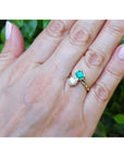 Natural colombian emerald and diamond two stone ring 18k yellow gold on a woman's hand.