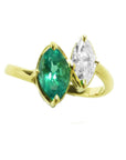 A 18k yellow gold you and me ring featuring a marquise-cut natural emerald and a marquise-cut diamond, toi et moi design.