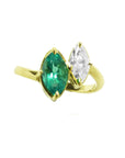 A 18k yellow gold you and me ring featuring a marquise-cut natural emerald and a marquise-cut diamond, toi et moi design.
