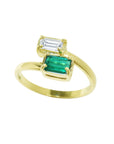 A 18k yellow gold ring featuring a toi et moi double emerald-cut gemstone setting with ar baguette natural diamond.