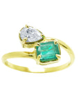 A stunning You and Me Muzo emerald ring for women, paired with a natural pear-cut diamond, made of 18k yellow gold.