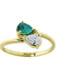 A 18k yellow gold You and Me ring featuring a pear-cut natural emerald and a pear-cut diamond, set on a polished gold band.