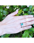 Anillo de oro blanco 18K con esmeralda colombiana rectangular verde profundo y diamantes, estilo antiguo.