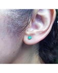 Martini emerald stud earring with a round green emerald in 14K white gold on an ear.