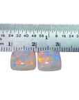 A matching pair of australian opals face up in front of a ruler for size measure.