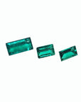 Three baguette-cut natural loose Colombian emeralds, vibrant deep bluish-green.