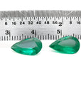 Matched pair of 3.62 carat pear-cut bluish-green Colombian emeralds with a ruler for scale.