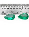 Matched pair of 3.62 carat pear-cut bluish-green Colombian emeralds with a ruler for scale.