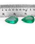 Matched pair of 3.62 carat pear-cut bluish-green Colombian emeralds with a ruler for scale.