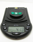 Three emerald-cut natural Colombian emeralds, 4.18 carats, on a black digital jewelry scale.