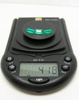 Three emerald-cut natural Colombian emeralds, 4.18 carats, on a black digital jewelry scale.