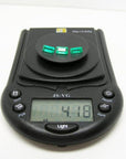 Three emerald-cut natural Colombian emeralds, 4.18 carats, on a black digital jewelry scale.